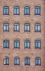 Fototapeta na wymiar Factory windows in the wall of an old buildng in Venice