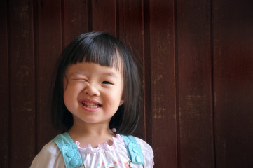 happy cute young girl wink with wooden background