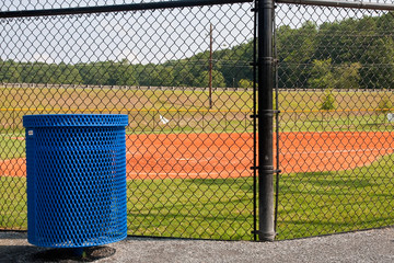 Blue Metal Trash Barrel by Baseball Field