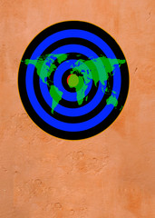 map of world over dartboard target on brown wall
