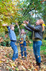 Family Group Relaxing Outdoors In Autumn Landscape