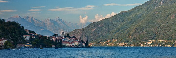 Fototapeta na wymiar Lago di Como coastline town with mountains in background.
