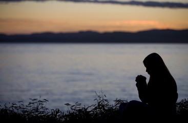 A Teenage Girl Praying Over Lake