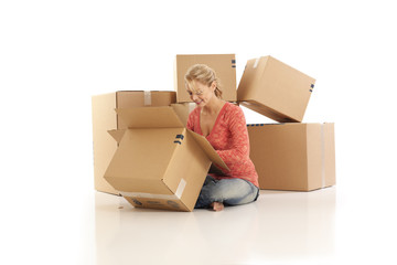 Young woman unpacking cardboard boxes