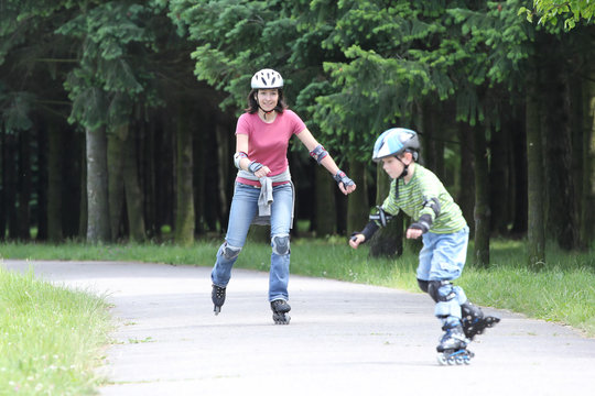 Happy family learning to ride on rollerblades