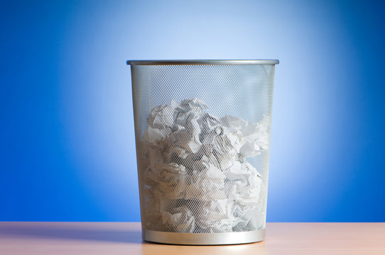 Garbage bin with paper waste isolated on white