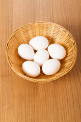 Many white eggs on the wooden table