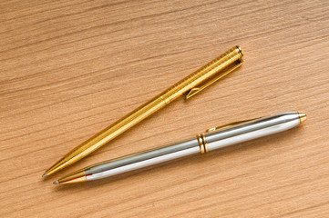 Writing silver pen on the wooden background