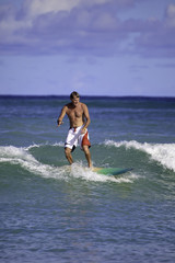 Fototapeta na wymiar sixty-four year old man surfing in hawaii
