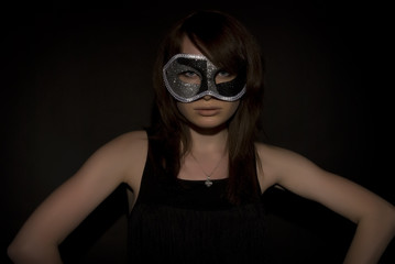 Portrait of a young girl in mask over black