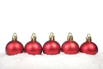 Row of red Christmas Balls in the snow,isolated on white backgro