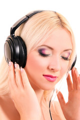 Beautiful young blonde woman with bright make-up listening music
