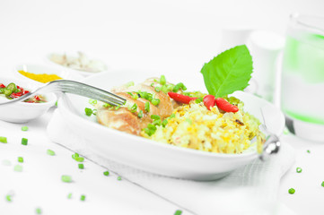 White plate with cury rice chicken fillet and basil