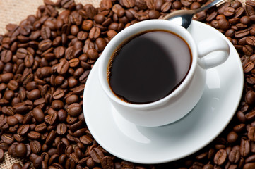 Cup of coffee on coffee grains