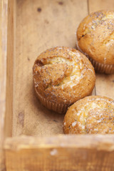 three poppy seeds and lemon muffins in wooden box