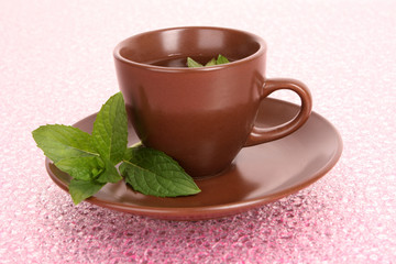 Cup of green tea on the saucer with mint