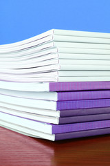 Pile of color magazines isolated on yellow background