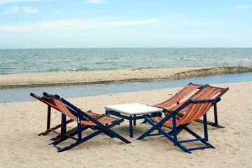 Fototapeta na wymiar sun beach chairs on shore near sea