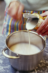 Verser du lait de coco dans une cocotte