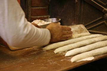 Boulanger formant ses baguettes de pain