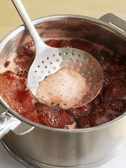 Retirer l'écume avec une écumoire 