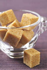 Morceaux de sucre roux dans une tasse transparente