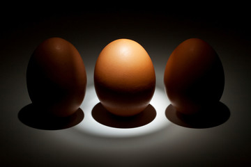 Lightened egg between two eggs in the dark