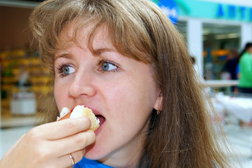 The girl eats hot dog