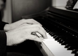 Close-up of a young man's hands playing a piano