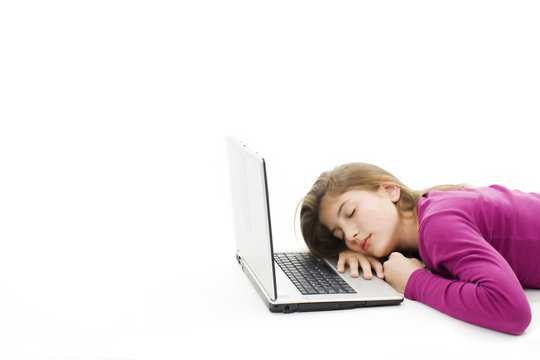 Cute teenage girl sleeping on her laptop computer