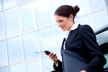 Young business woman outside, reading sms