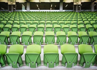 Fototapeta premium Rows of folded seats in empty stadium. Focus on front seats