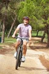 Fototapeta na wymiar Senior man enjoying bike ride in park