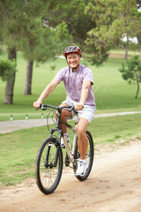 Senior man enjoying bike ride in park