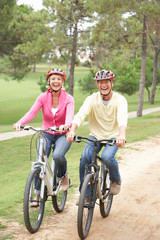 Obraz premium Senior couple riding bicycle in park