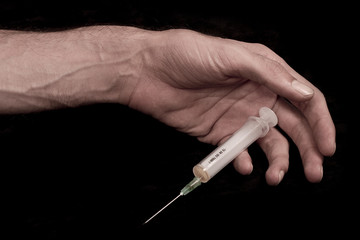 End of drug use. Dead drug addict. Syringe in hand.