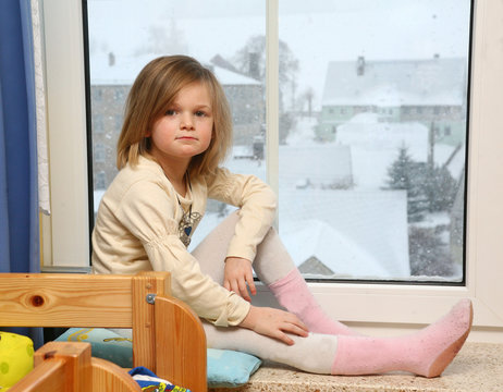 junges M&auml;dchen sitzt am Fenster