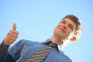 young businessman shows super on the blue sky