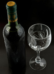 Bottle and wineglass on black background