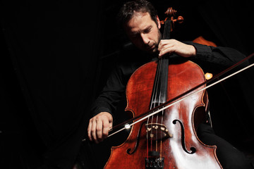 Cellist playing classical cello music on black background © logoboom
