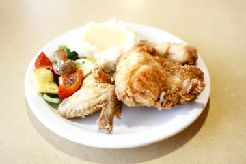 Fried chicken with a side of mashed potatoes and vegetables