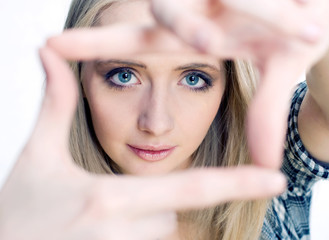 Young girl posing her hands like photo frame