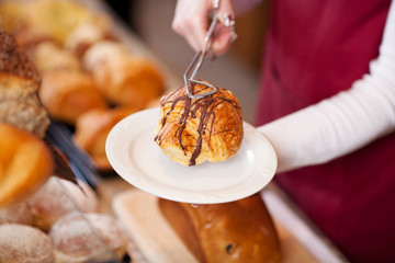 verkäuferin serviert schokocroissant
