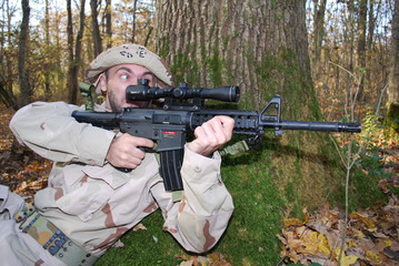 us marine in desert uniform aiming his gun