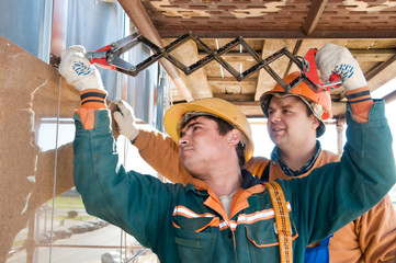 Worker builders at facade tile installation