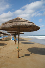 Endlich Urlaub: Sonnenschirme aus Stroh am Sandstrand
