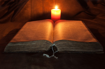 Bible lighted by a Candle