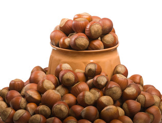 Hazelnuts scattered around the jug