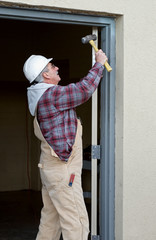 Worker Securing Door Frame