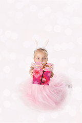 little girl in a pink dress with ears of a rabbit on a head